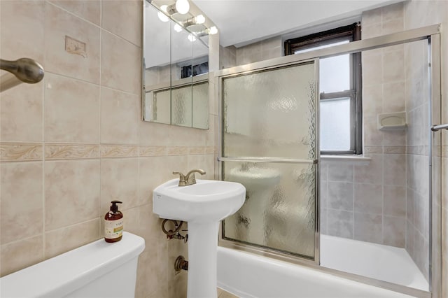 61-35 98th St Unit 4J, Rego Park, NY 11374 - bathroom featuring tile walls, toilet, combined bath / shower with glass door, and a sink