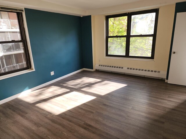 61-35 98th St Unit 4J, Rego Park, NY 11374 - empty room with baseboard heating, wood finished floors, and baseboards
