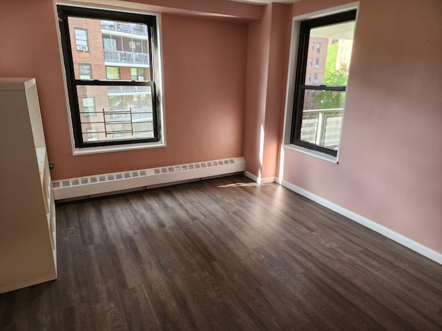 61-35 98th St Unit 4J, Rego Park, NY 11374 - spare room with a baseboard radiator, baseboards, and dark wood-type flooring