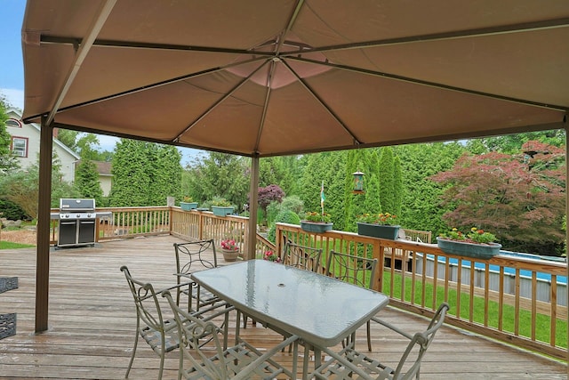 wooden deck with outdoor dining area and a grill
