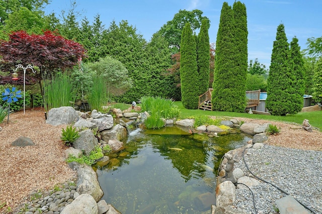 view of property's community featuring a garden pond