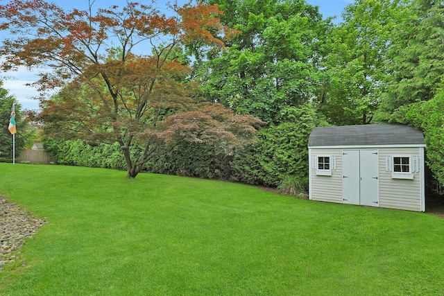 view of green lawn featuring a storage unit and an outdoor structure