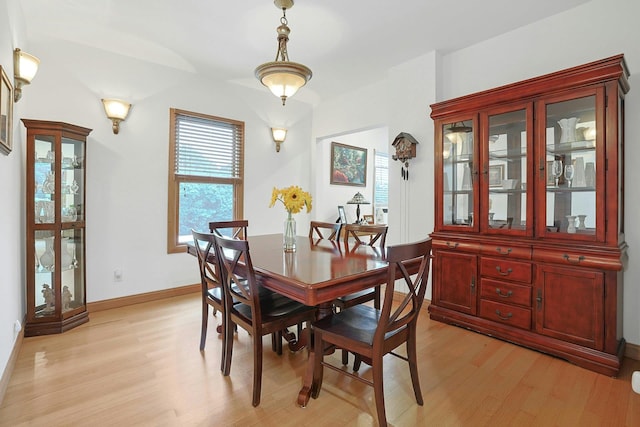 dining space with light wood-type flooring and baseboards