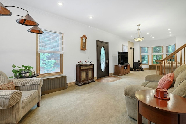 living room with light colored carpet, recessed lighting, crown molding, baseboards, and stairs