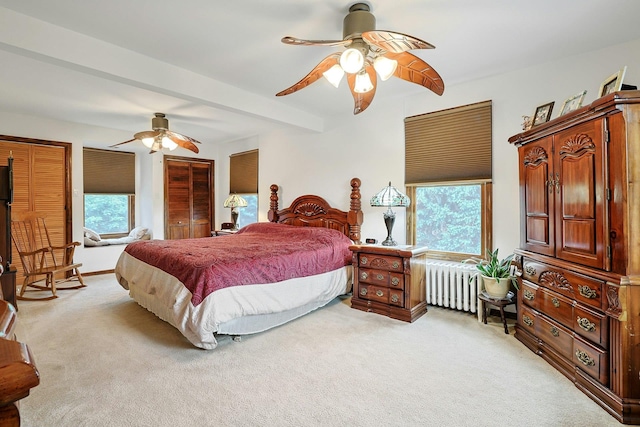 bedroom featuring radiator, light carpet, and ceiling fan