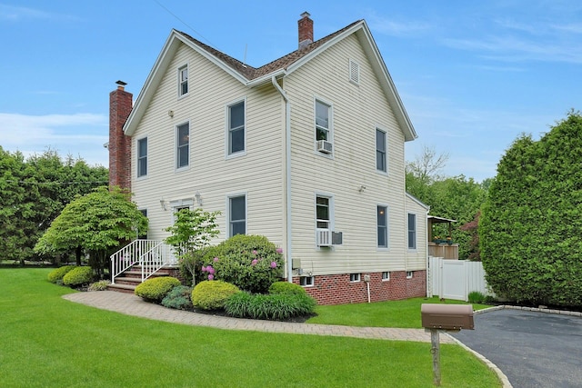 view of home's exterior featuring a chimney and cooling unit