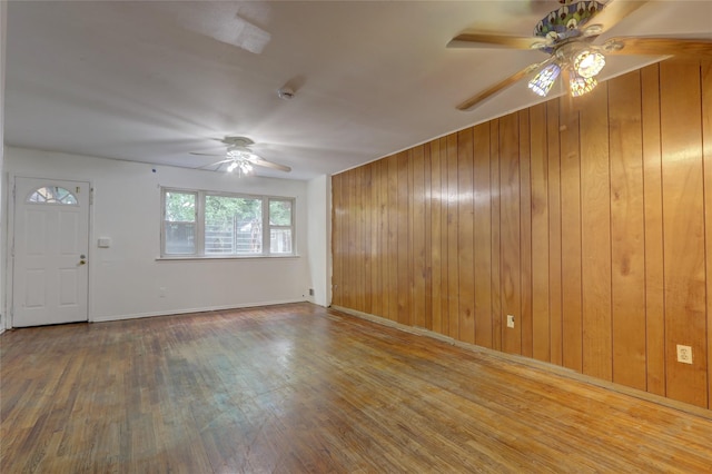 122-52 Springfield Blvd, Springfield Gardens, NY 11413 - unfurnished living room featuring ceiling fan, wood walls, wood finished floors, and baseboards
