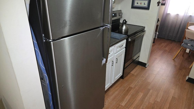 1115 Cherry Hill Dr, Poughkeepsie, NY 12603 - kitchen featuring appliances with stainless steel finishes, wood finished floors, white cabinetry, and dark countertops