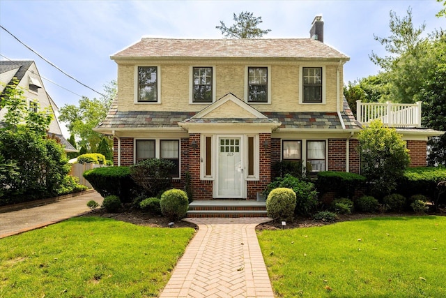 265 Brower Ave, Rockville Centre, NY 11570 - view of front of home featuring a chimney, a front lawn, and brick siding