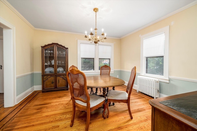265 Brower Ave, Rockville Centre, NY 11570 - dining area featuring radiator heating unit, light wood-style flooring, a chandelier, and crown molding