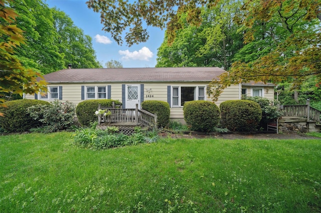ranch-style home with a front lawn and a deck