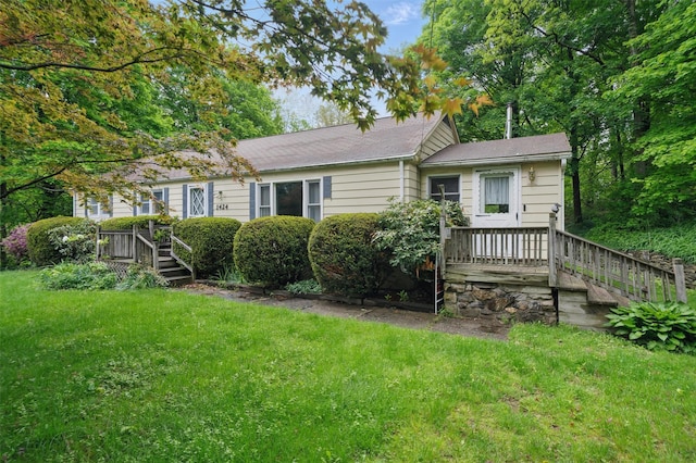 view of front of house with a front yard and a wooden deck