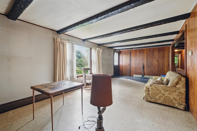 living room with beam ceiling, wood walls, carpet floors, and a baseboard radiator