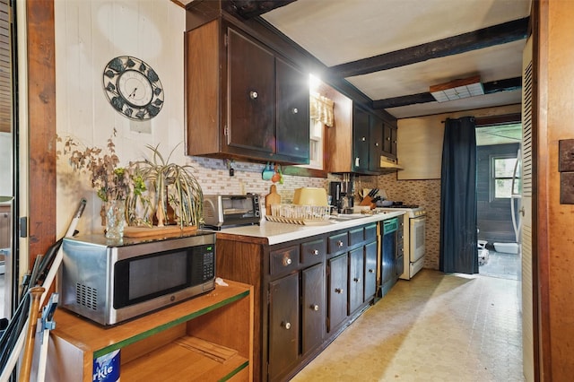 kitchen with stainless steel microwave, white range with gas stovetop, light countertops, and dark brown cabinetry