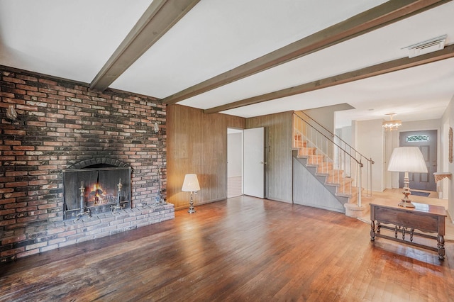 39 Pinewood Dr, Commack, NY 11725 - living area featuring stairs, beam ceiling, a fireplace, wood finished floors, and a chandelier