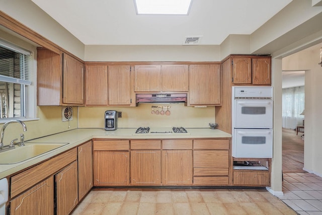 39 Pinewood Dr, Commack, NY 11725 - kitchen featuring white appliances, a sink, under cabinet range hood, light countertops, and brown cabinets