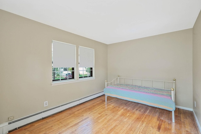 39 Pinewood Dr, Commack, NY 11725 - bedroom featuring baseboard heating, wood-type flooring, and baseboards