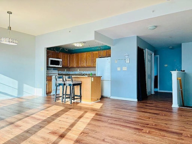 162 Commodore Cir E, Arverne, NY 11692 - kitchen featuring white appliances, light wood-style floors, and baseboards
