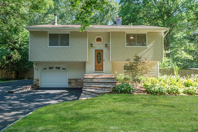 27 Columbus Ave, Kings Park, NY 11754 - raised ranch featuring an attached garage, driveway, a chimney, and stone siding