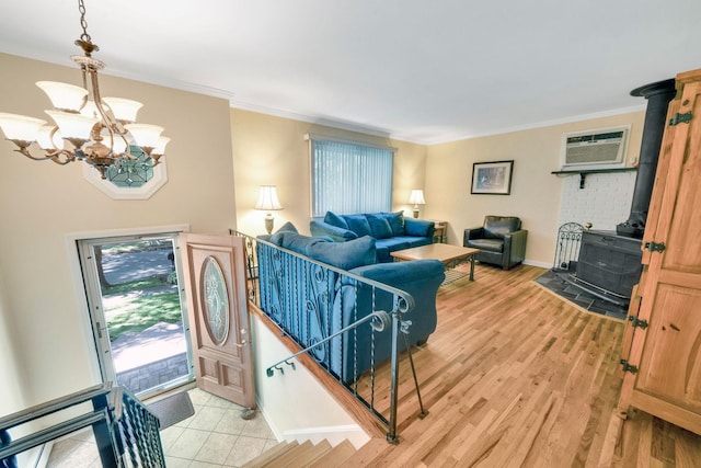 27 Columbus Ave, Kings Park, NY 11754 - entrance foyer with a wood stove, a chandelier, crown molding, light wood finished floors, and a wall unit AC