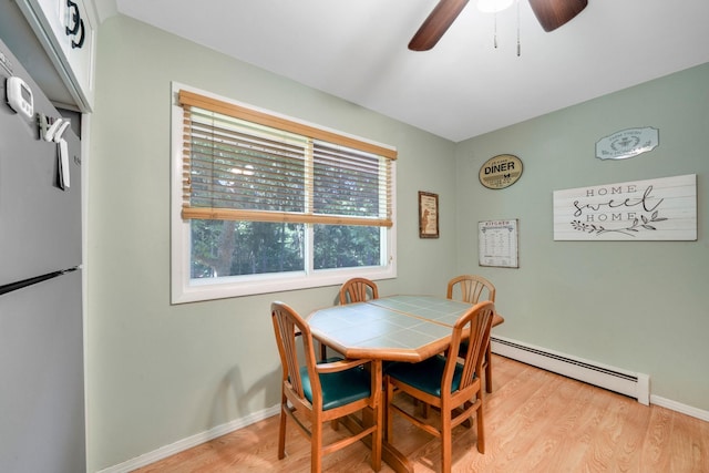 27 Columbus Ave, Kings Park, NY 11754 - dining area featuring baseboard heating, light wood finished floors, and a ceiling fan