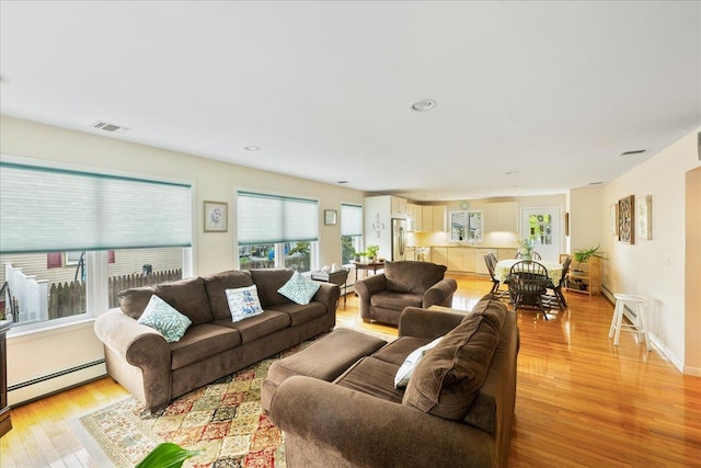 living room featuring a baseboard radiator and light wood finished floors