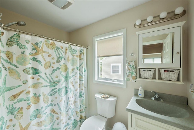 bathroom with toilet, vanity, and curtained shower