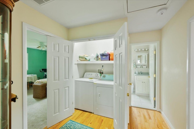 washroom with independent washer and dryer, light wood-style floors, and ceiling fan