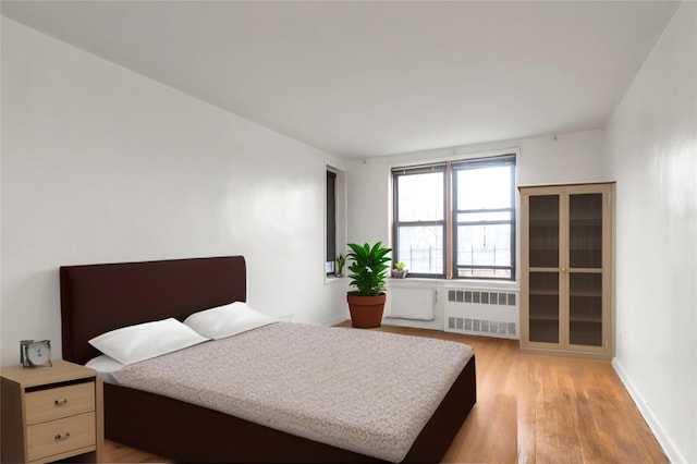 87-70 173rd St Unit 6H, Jamaica, NY 11432 - bedroom with radiator, light wood finished floors, and baseboards