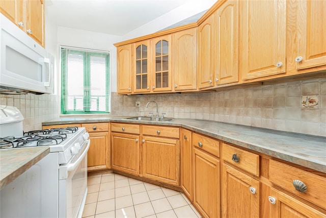 kitchen with white appliances, a sink, light tile patterned flooring, and tasteful backsplash