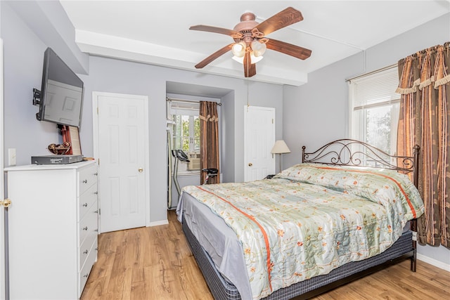bedroom with multiple windows, light wood finished floors, baseboards, and ceiling fan