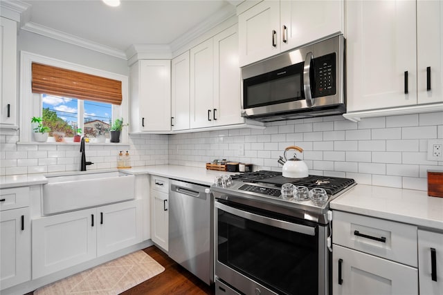 8 Vera Ct, West Islip, NY 11795 - kitchen with stainless steel appliances, a sink, ornamental molding, dark wood finished floors, and white cabinets