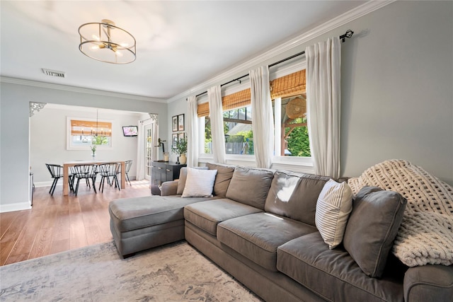 8 Vera Ct, West Islip, NY 11795 - living room featuring a chandelier, ornamental molding, wood finished floors, healthy amount of natural light, and baseboards