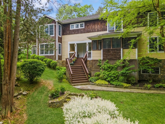 125 Hawkes Ave, Ossining, NY 10562 - view of front of house with stairs, a sunroom, and a front lawn