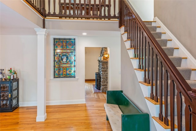125 Hawkes Ave, Ossining, NY 10562 - stairs featuring wood finished floors, baseboards, ornate columns, and a towering ceiling
