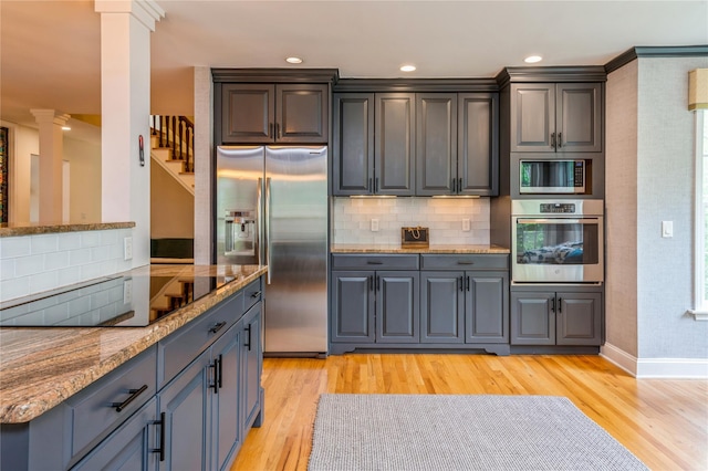 125 Hawkes Ave, Ossining, NY 10562 - kitchen featuring appliances with stainless steel finishes, decorative columns, light wood finished floors, tasteful backsplash, and recessed lighting