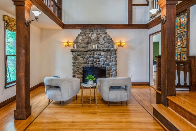 125 Hawkes Ave, Ossining, NY 10562 - living area featuring wood-type flooring, baseboards, a stone fireplace, and decorative columns