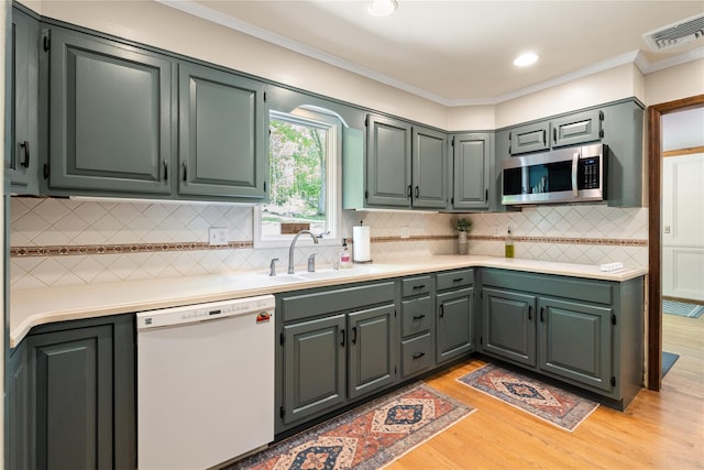 50 Maple Wood Dr, Brewster, NY 10509 - kitchen featuring white dishwasher, a sink, stainless steel microwave, light wood-style floors, and light countertops