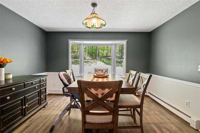 50 Maple Wood Dr, Brewster, NY 10509 - dining area featuring a baseboard radiator, light wood finished floors, and a textured ceiling