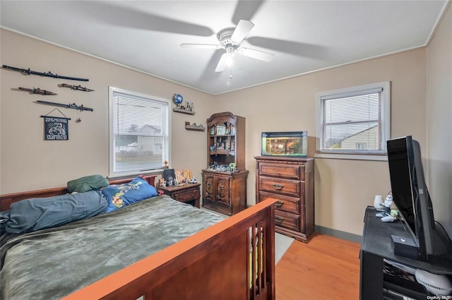 bedroom featuring light wood-style floors, baseboards, and a ceiling fan