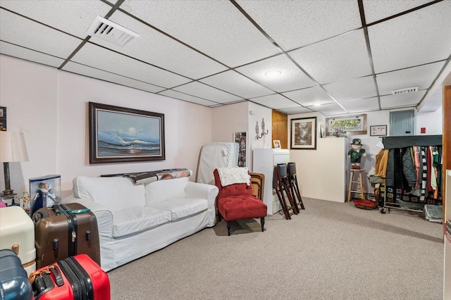 carpeted living room with a paneled ceiling