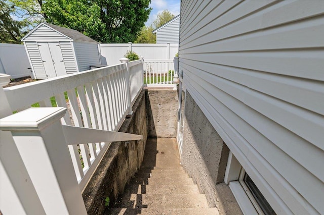 wooden deck featuring a shed, an outdoor structure, and fence