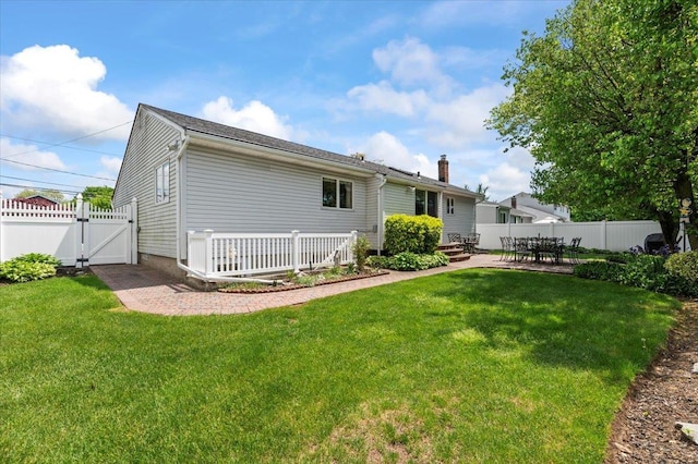 back of property featuring a gate, a patio area, and a chimney