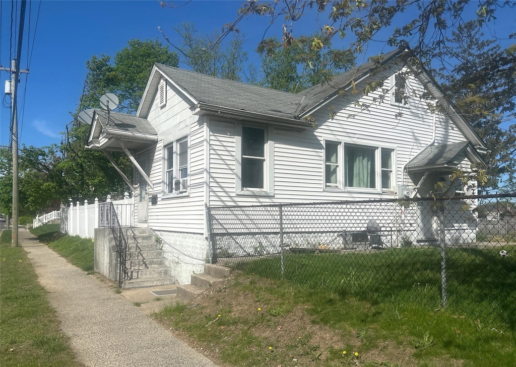 view of home's exterior with fence and roof with shingles