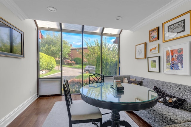 dining room with ornamental molding, wood finished floors, baseboards, a wall of windows, and recessed lighting