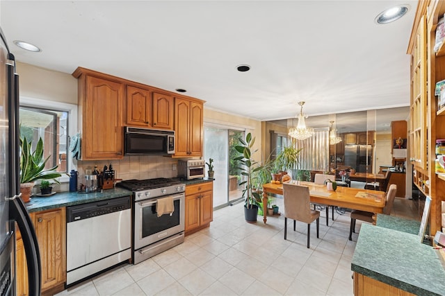 539 Keller Ave, Elmont, NY 11003 - kitchen featuring stainless steel appliances, a chandelier, dark countertops, and brown cabinetry