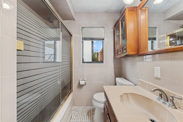 539 Keller Ave, Elmont, NY 11003 - full bath featuring toilet, tile walls, vanity, tile patterned floors, and combined bath / shower with glass door