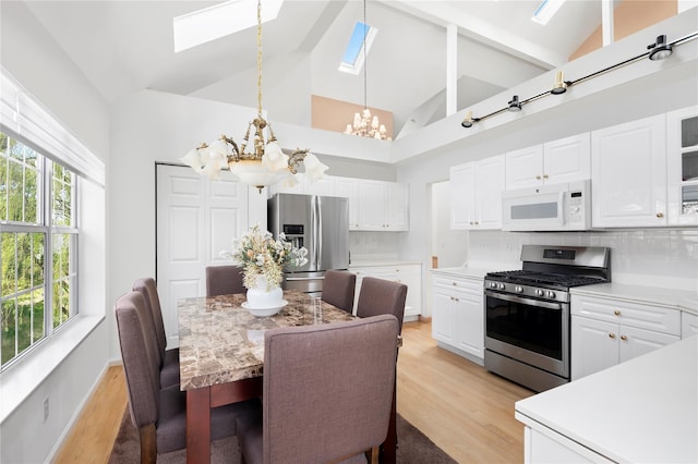 58 Roundtop Rd, Yonkers, NY 10710 - kitchen with stainless steel appliances, a chandelier, a skylight, high vaulted ceiling, and light wood-type flooring