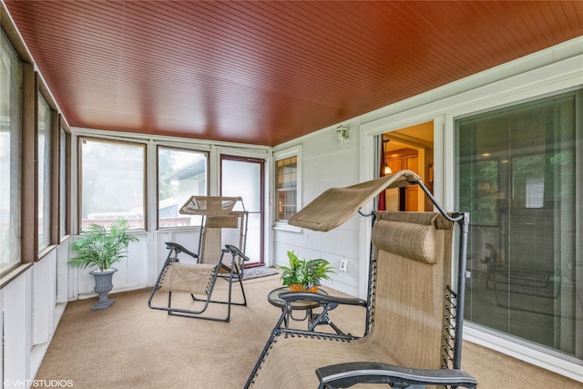 sunroom with carpet flooring and wood ceiling