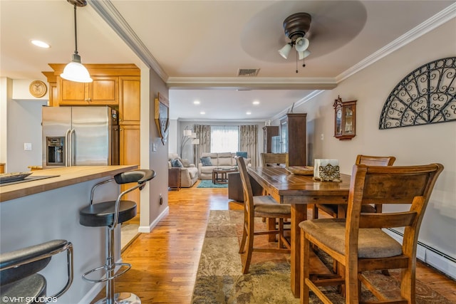 dining room with crown molding, a ceiling fan, light wood-type flooring, a baseboard radiator, and recessed lighting